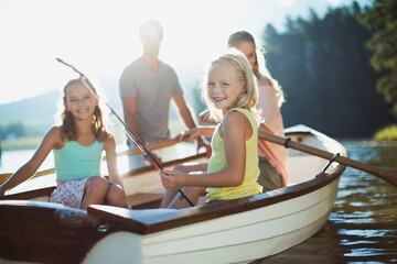Smiling family in rowboat on lake