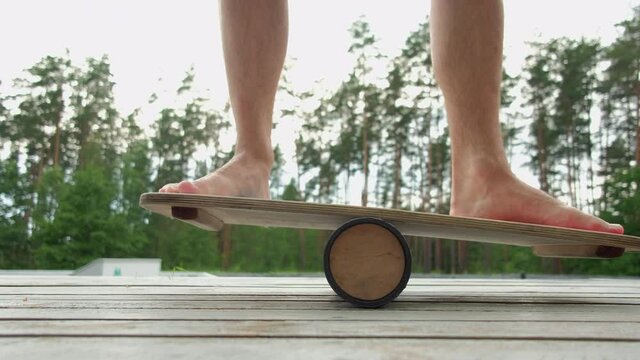 Man standing on balance board outdoors. Healthy lifestyle, sport concept