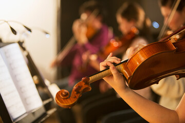 Violinist performing in orchestra © Tom Merton/KOTO