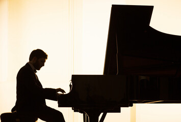 Silhouette of pianist performing - obrazy, fototapety, plakaty