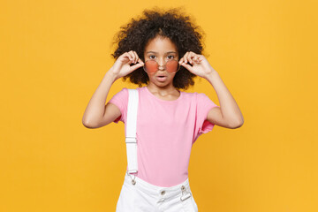 Shocked little african american kid girl 12-13 years old in pink t-shirt eyeglasses isolated on...