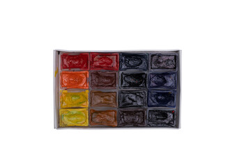 Set of piece multi-colored watercolor paints in a rectangular white cardboard box Isolated on a white background. Rectangular paints. Paints are not new and dry.