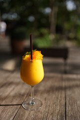 Mango smoothie serves with egg threads topping on the wood in summer.