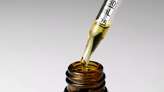 cdb oil with measuring pipet drop in tho the amber glass bottle. for cosmetic, treatment , health and supplement.