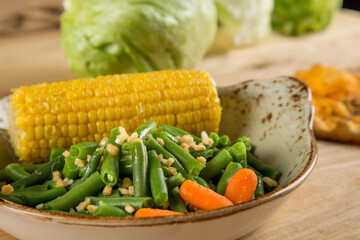 Beans and corn in a plate, next to it lies bread and beet cutlets