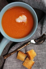 Homemade Tomato carrot soup in a bow made with frsh Tomatoes.