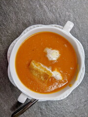 Homemade Tomato carrot soup in a bow made with frsh Tomatoes.