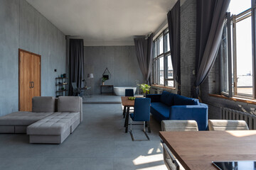 Modern minimalistic dark gray loft style studio apartment interior design. kitchen, sitting area, workplace, shower and bath. bright sun rays inside.