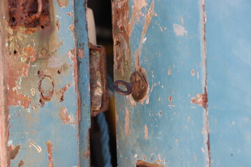 Old rusty blue door, open, close up key in lock 