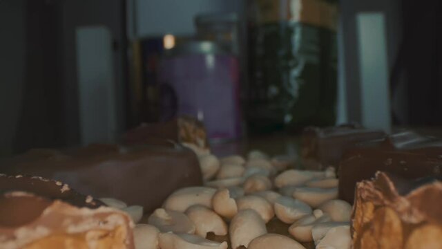 Macro close up view of the broken chocolate bar of chocolate with cashew nuts and coconut.