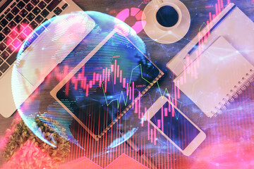 Double exposure of business theme hologram over desktop with phone. Top view. Mobile international...