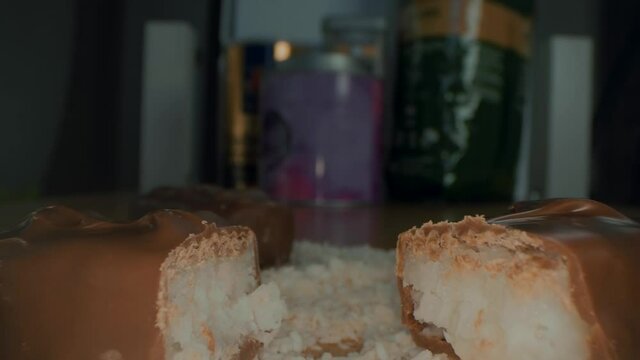 Macro close up view of the broken chocolate bar of chocolate with cashew nuts and coconut.