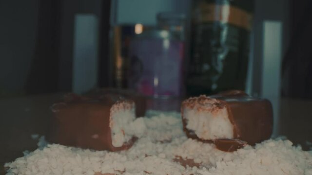 Macro close up view of the broken chocolate bar of chocolate with cashew nuts and coconut.
