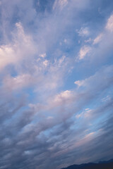 Amazing dramatic cloudy sky in white, blue and purple tones with sunlight