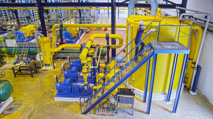 worker ascending stairs in industrial installation
