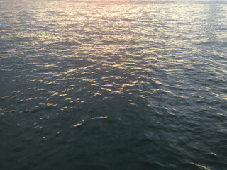 Calm water in New York Harbor. Reflection of sunset in the ocean water. Background sea water texture.