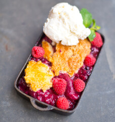 Raspberry Cobbler. Classic American Dessert favorite. Fresh fruit simmered in sugar and spices and baked in a cast iron pan with cobbler crumble on top.