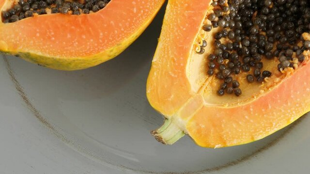 Ripe half cut papaya fruit. Rotate on plate