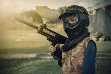 boy Gotcha player with protective mask, gun and wild attitude. Paint Bullet Players