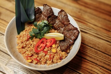 Fried rice with beef and vegetables in a waiter's hand with a glove