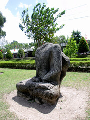 Klaten, Indonesia - August 03 2018: Side view of a headless man stone statue with meditating ascetic sitting position (bertapa/bersemedi) at Sojiwan Temple (Taman Wisata Candi Sajiwan) area.