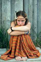 Portrait of a young hippie girl, sit outdoor in the village.