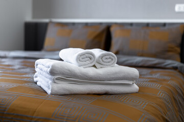 White bath towels on bed in hotel.