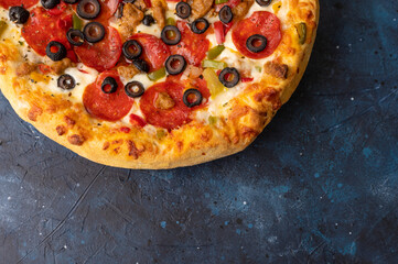 Tasty pepperoni pizza on a blue concrete background. Top view of hot pepperoni pizza. Banner