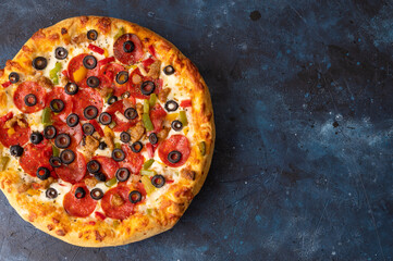 Tasty pepperoni pizza on a blue concrete background. Top view of hot pepperoni pizza. Banner