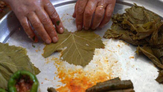 A woman is preparing stuffed grape leaves, leaf wrap, Turkish food culture and stuffed leaves