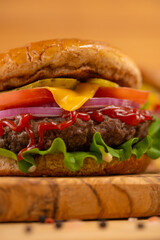 Fast food, close-up hamburger on a wooden table, tasty and unhealthy food