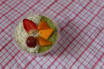 fruit salad of melon, grape, strawberry, kiwi dressed with natural yoghurt and sprinkled with chopped Apple