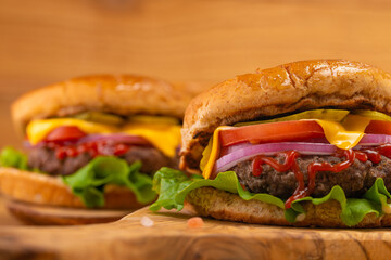 Fast food, close-up hamburger on a wooden table, tasty and unhealthy food