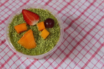 fruit salad of melon, grape, strawberry, kiwi dressed with natural yoghurt and sprinkled with chopped Apple
