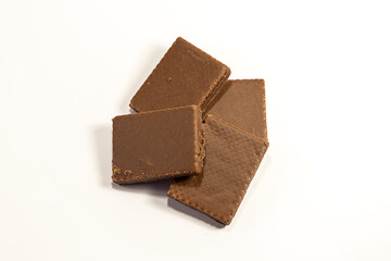 Macro photo of Chocolate bar. Broken pieces over white background