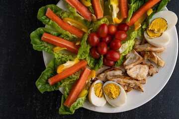 Top View Fresh chicken salad with crab sticks and boiled eggs.