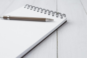Selective focus of Pen and notebook  on white wooden table and copy space