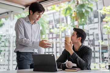 Group of young asian modern people in smart casual wear having a brainstorm meeting. Group of young asian business people discussing in the meeting.