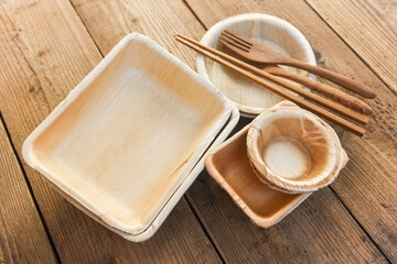 Natural eco-friendly food packaging disposable utensils with dish plate bowl cup and wooden fork...
