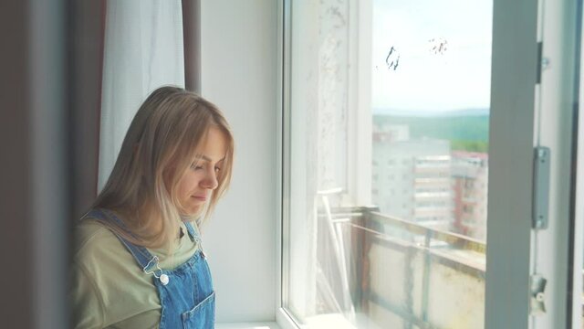 The girl is professionally wash the Windows in the apartment, cleaning