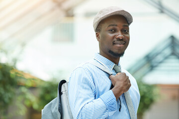 Portrait of African young businessman smiling at camera while standing outdoors