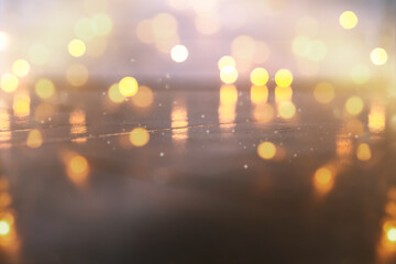 Empty rustic wooden table with blurred Christmas lights at background. Light gold bokeh of cafe restaurant in dark background.