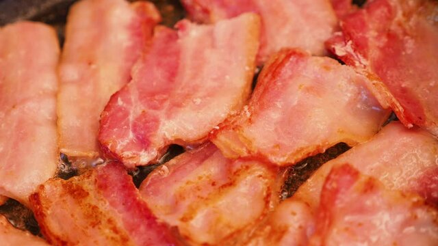 Frying bacon in a pan. Cooking meat.