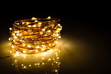 Yellow colored light chain for decoration placed on a reflective surface