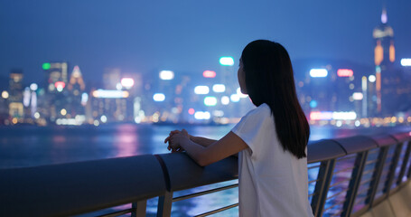 Woman looks at the city view in evening