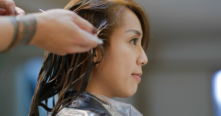 Woman dye her hair at beauty salon