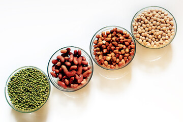 Collection of legumes (chickpeas, green peas, Pink lentils, Indian lentils, red beans, green mung beans, Red Kidney) isolated on white background.