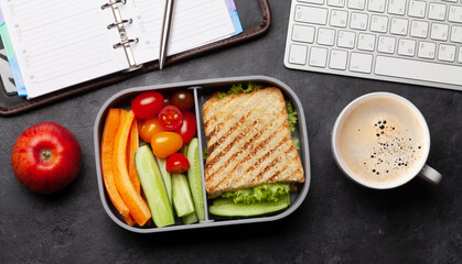 Healthy lunch box with sandwich and vegetables