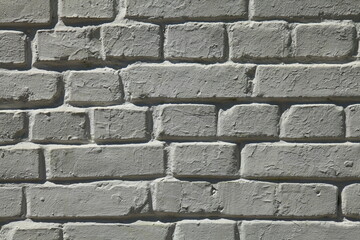 Dim brick wall texture, background in white color. The building wall, painted with whitewased water-based paint. Light-dark or dull white brickwork surface with uneven masonry