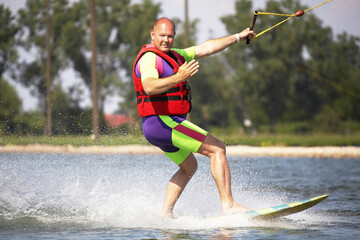 Älterer Mann beim Wassersport winkt